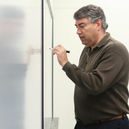 Faculty member writing something on board